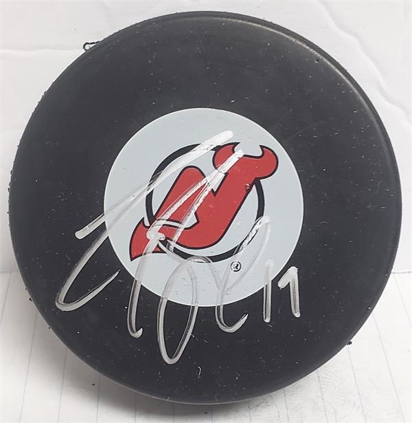 Picture of Autograph Warehouse 783372 Travis Zajac Autographed Hockey Puck - Jersey Devils with Display Cube