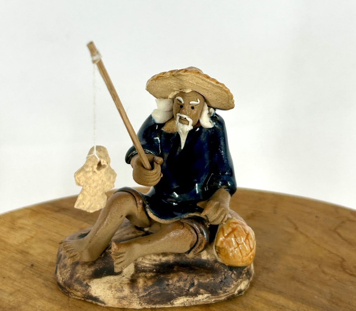 e3600 2.5 in. Miniature Ceramic Glazed Fisherman Figurine with Sitting On A Log, Blue