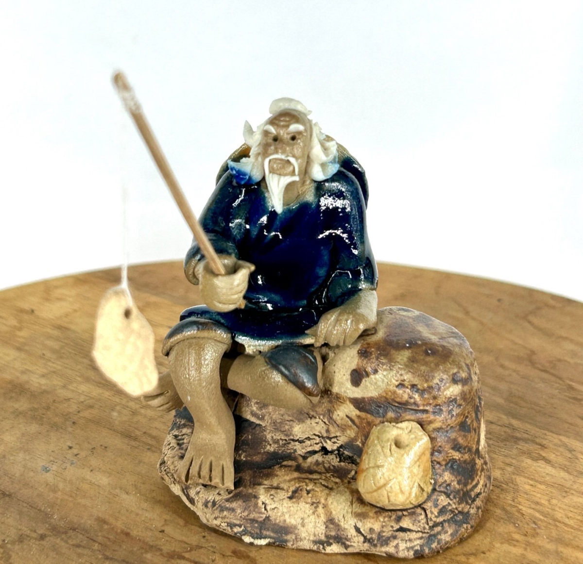 e3600a Miniature Ceramic Glazed Fisherman Figurine with Sitting On A Log, Blue - 2.5 in.