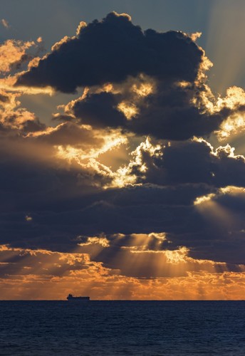 DPI12284926 Dramatic Sky with Clouds Glowing At Sunset Over The Ocean & A Ship in The Poster Print by Ben Welsh, 12 x 18
