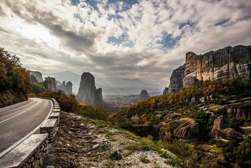 Landscape of Rugged Cliffs Road Autumn Foliage & Monastery Rousanou in The Distance - Meteora Greece Poster Print by Reynold Mainse - 19 x 12