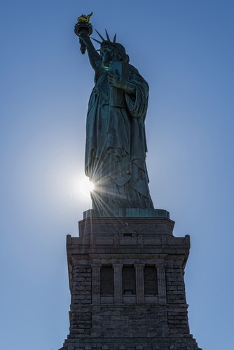 Sun Setting Behind The Statue of Liberty Liberty Island - New York City United States of America Poster Print by F. M. Kearney, 24 x 38 - Large