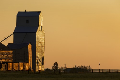 Wooden Grain Elevator Reflecting The Orange Glow of Sunrise - Mossleigh Alberta Canada Poster Print by Michael Interisano, 38 x 24 - Large