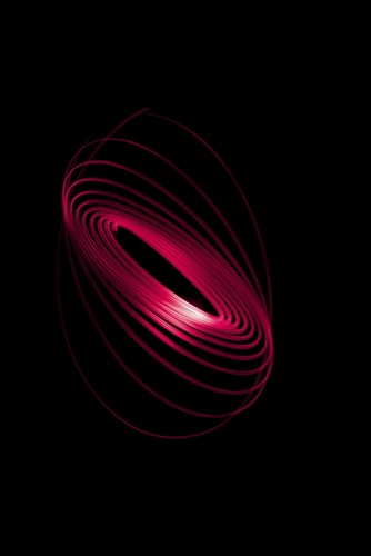 Red Light Curving in a Sphere Shape On A Black Background Poster Print by Nick Dale