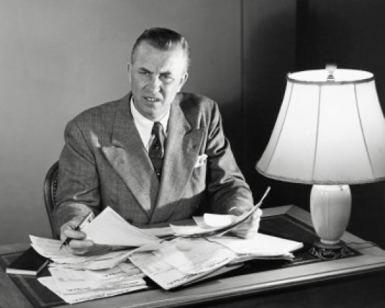 Businessman Doing Paperwork in an Office Poster Print - 18 x 24 in.