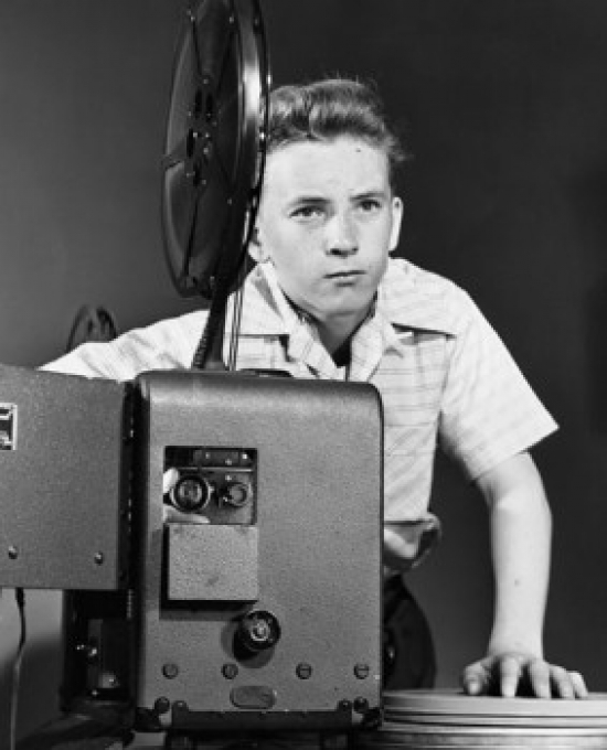 Boy Adjusting a Projector Poster Print - 18 x 24 in.