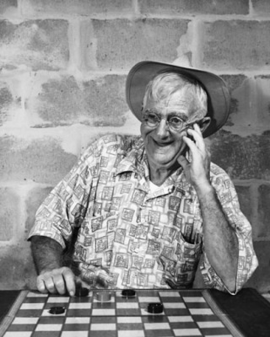 Mature Man Playing Checkers & Smiling Poster Print - 18 x 24 in.