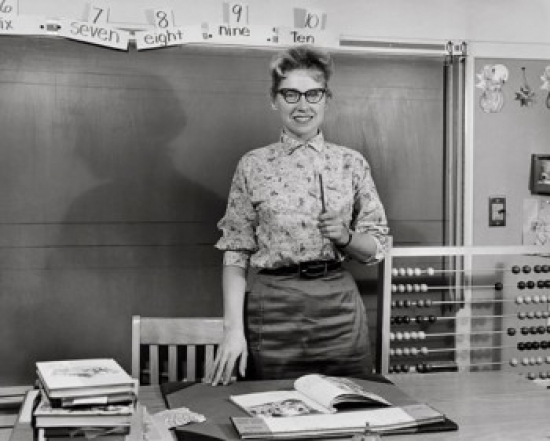 Teacher Smiling in a Classroom Poster Print - 18 x 24 in.