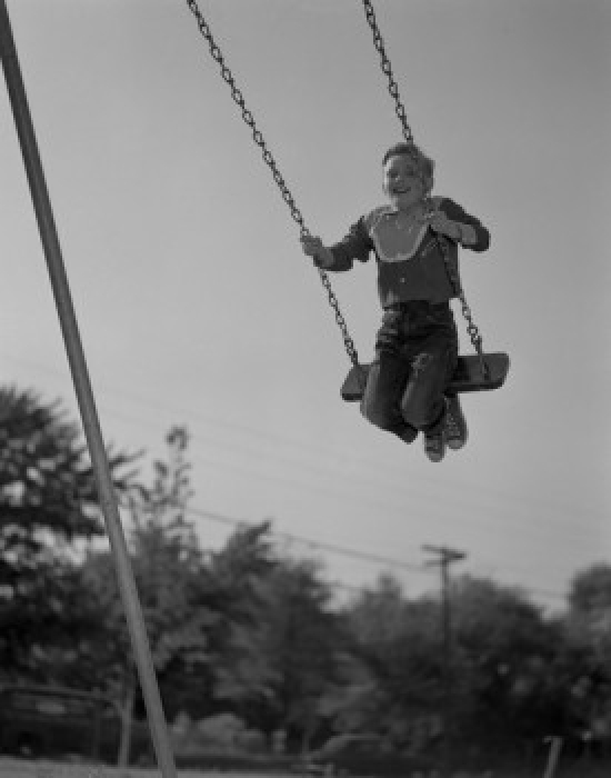 Low Angle View of a Boy on a Swing Poster Print - 18 x 24 in.