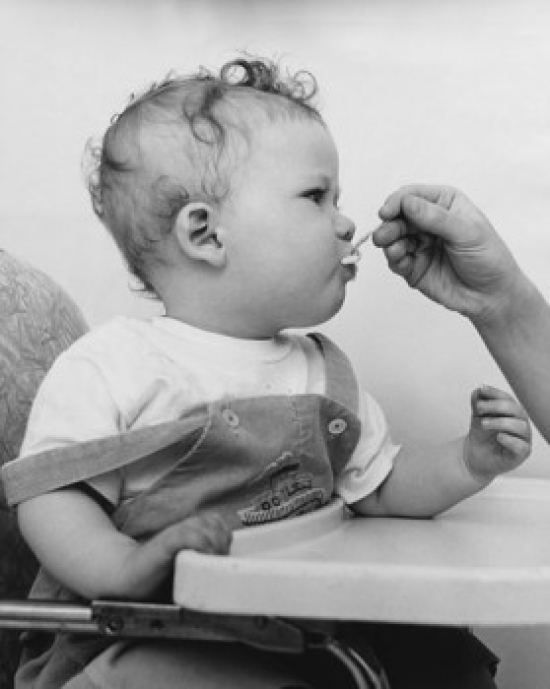 SAL2559691 Close-Up of a Persons Hand Feeding a Baby Sitting in a High Chair Poster Print - 18 x 24 in -  Posterazzi