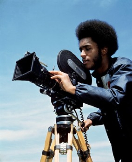 Young Man Operating a Movie Camera Poster Print - 18 x 24 in.