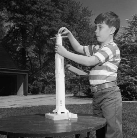 Boy Playing with Toy Rocket Poster Print - 18 x 24 in.