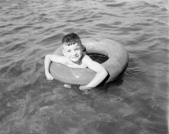 Boy Swimming in Inflatable Ring Poster Print - 18 x 24 in.