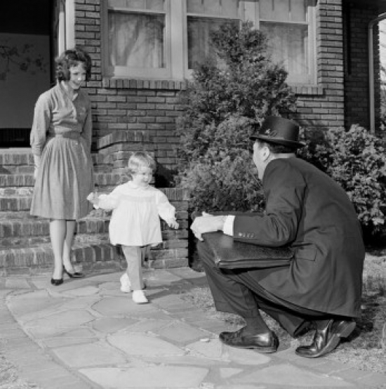 Businessman Saying Hello to Wife & Young Daughter As He Comes Back From Work Poster Print - 18 x 24 in.