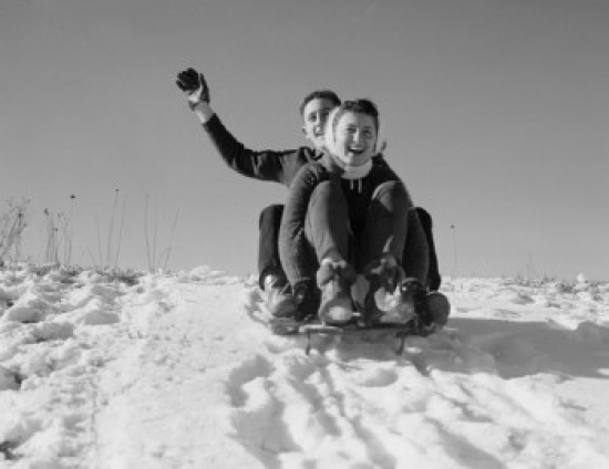 Young Couple Sledding Down Snowy Hill Poster Print - 18 x 24 in.