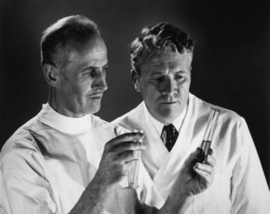 Two Scientists Analyzing Chemicals in Two Test Tubes Poster Print - 18 x 24 in.