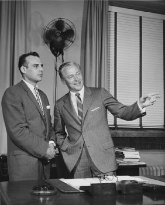 Two Businessmen Standing in Office Poster Print - 18 x 24 in.