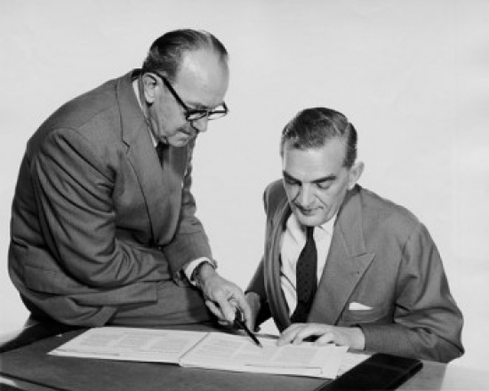 Side Profile of Businessman Explaining Documents to Another Businessman Poster Print - 18 x 24 in.
