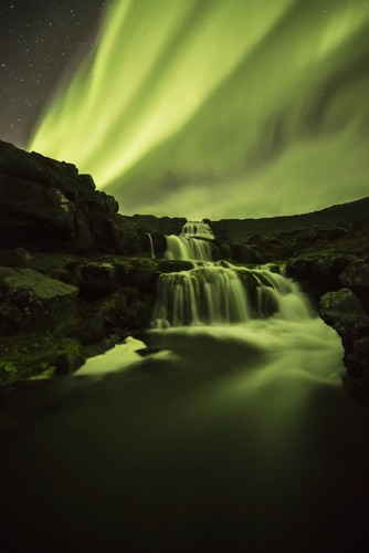 Northern Lights Or Aurora Borealis Glowing Over Waterfalls & A Stream - Iceland Poster Print by Robert Postma - 12 x 19