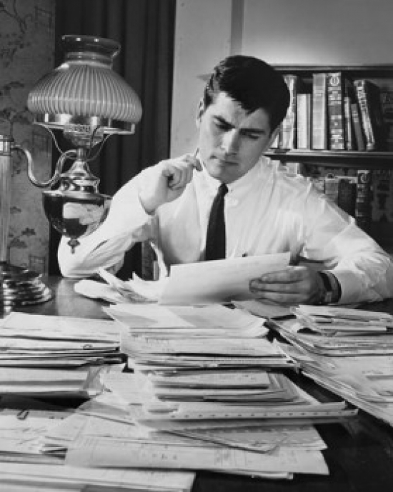 Businessman Reading Documents in an Office Poster Print - 18 x 24 in.