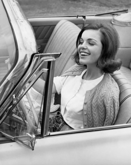 Close-Up of a Young Woman Sitting in a Car & Smiling Poster Print - 18 x 24 in.