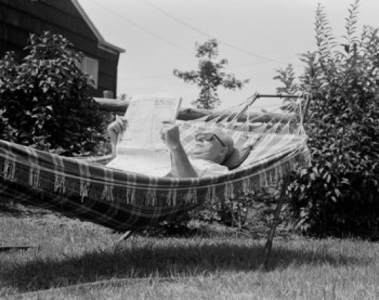 Senior Man Reading Newspaper in Hammock Poster Print - 18 x 24 in.