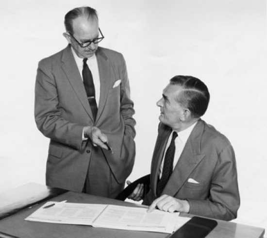 Businessman Discussing Over Documents Poster Print - 18 x 24 in.