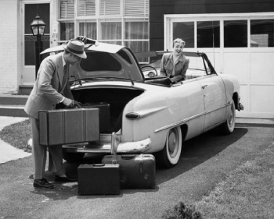 Side Profile of a Young Man Loading Luggage Into a Car Trunk Poster Print - 18 x 24 in.