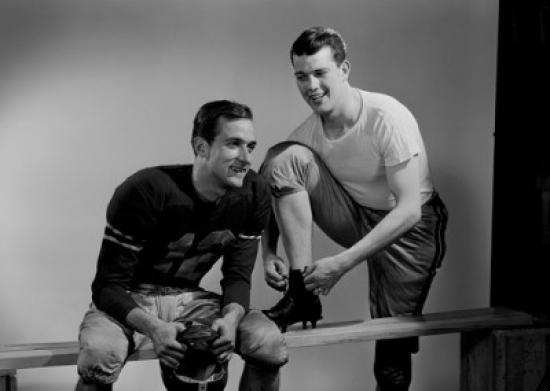 Two Football Players Getting Dressed Poster Print - 18 x 24 in.