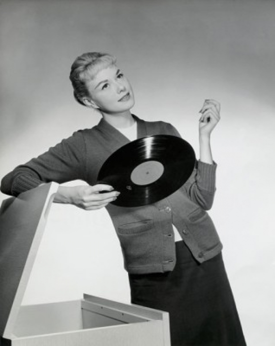 SAL2554856 Close-Up of a Young Woman Leaning on a Box & Holding a Record 1958 Poster Print - 18 x 24 in.