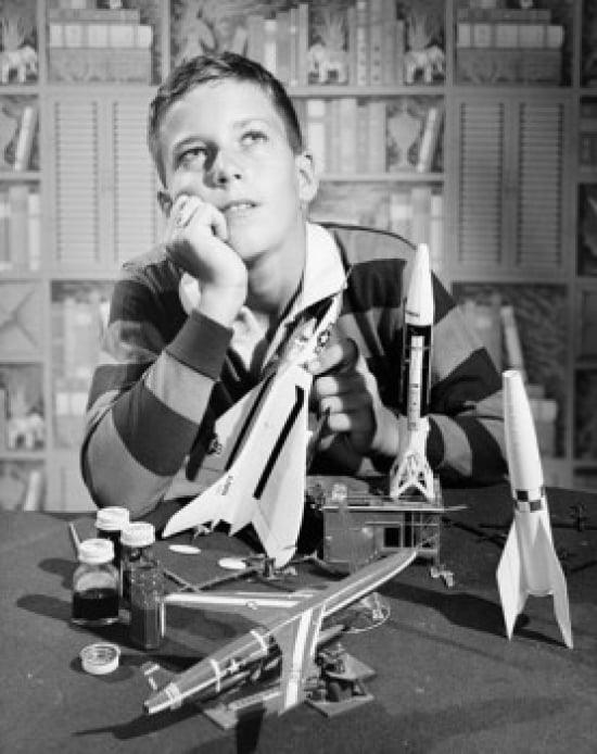 Boy Holding Model Airplane & Looking Up Poster Print - 18 x 24 in.