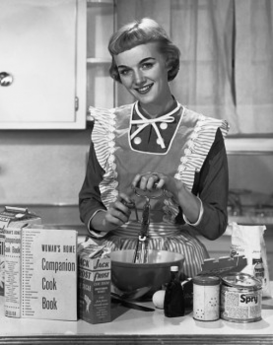 Portrait of a Young Woman Preparing Food in the Kitchen & Smiling Poster Print - 18 x 24 in.