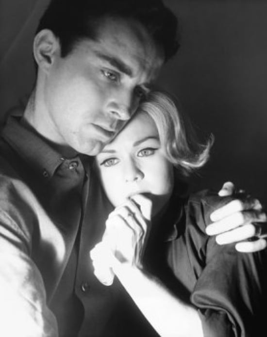 Close-Up of a Young Man Embracing a Young Woman & Looking Serious Poster Print - 18 x 24 in.