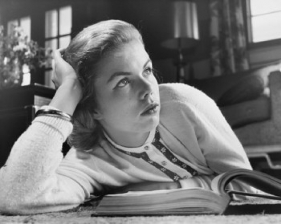 Close-Up of a Teenage Girl Lying on the Floor with an Open Book in Front of Her Poster Print - 18 x 24 in.