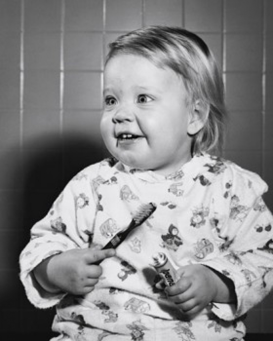 Close-Up of a Baby Holding a Toothbrush & Toothpaste Poster Print