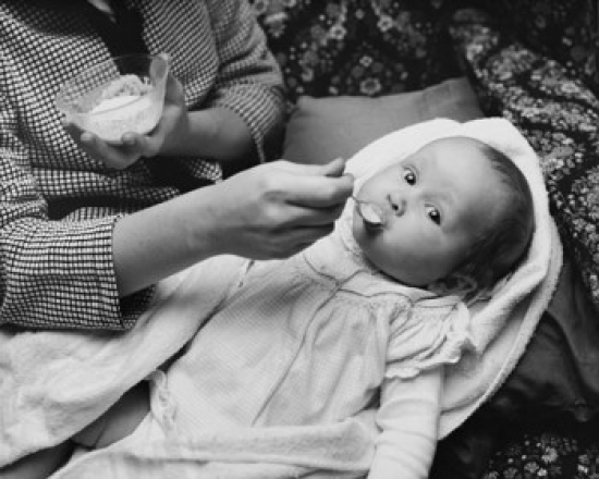Mid Section View of a Woman Feeding Her Daughter Poster Print - 18 x 24 in.