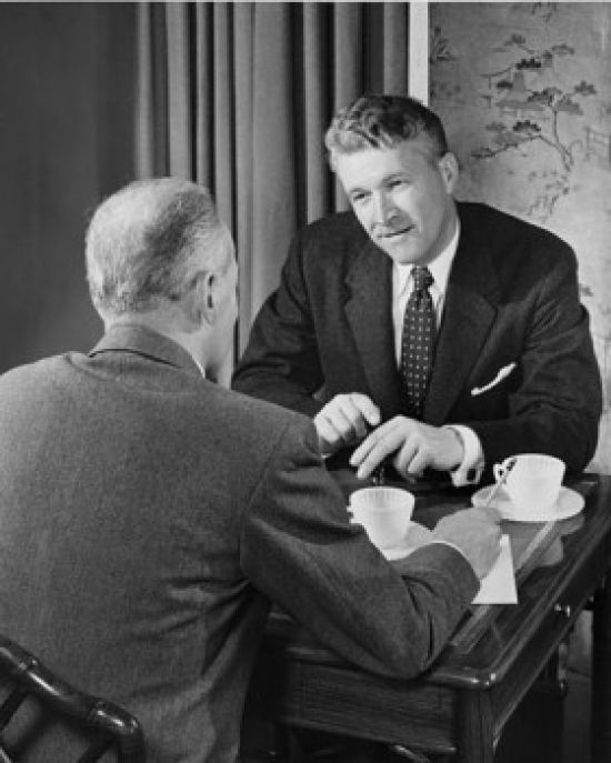 Two Businessmen Talking Indoors Poster Print - 18 x 24 in.