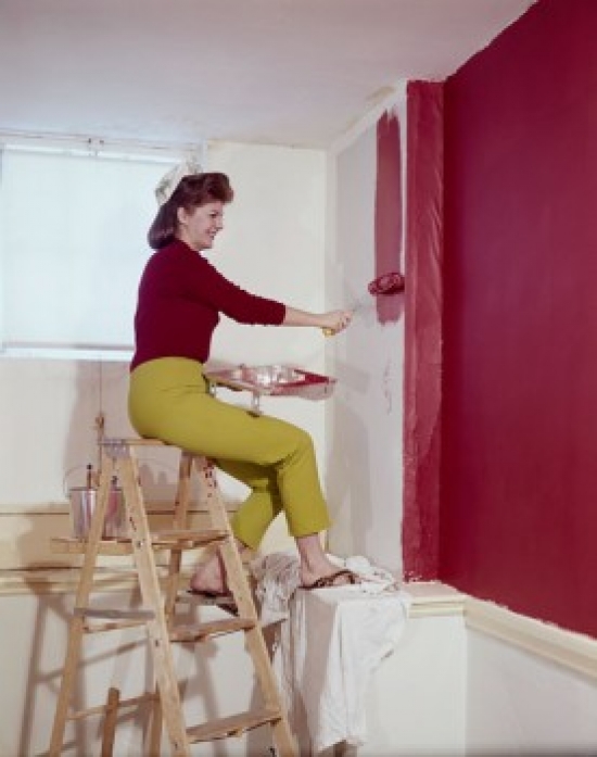Side Profile of a Mid Adult Woman Painting a Wall with a Paint Roller Poster Print - 18 x 24 in.