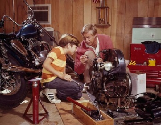 Mature Man Explaining an Automobile Engine to His Son in a Workshop Poster Print - 18 x 24 in.