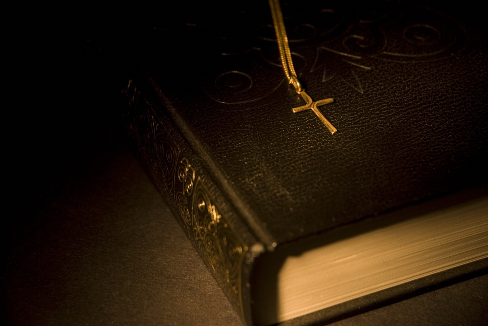 Gold Cross Pendant Resting On A Book Poster Print, 17 x 11