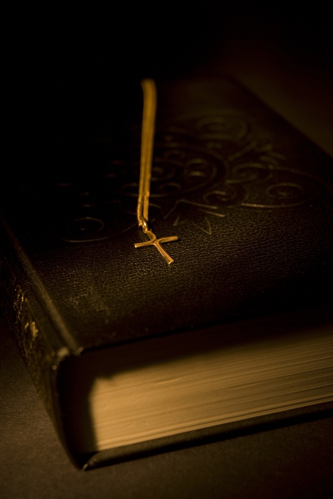 DPI1844704 Gold Cross Pendant Resting On A Book Poster Print, 11 x 17