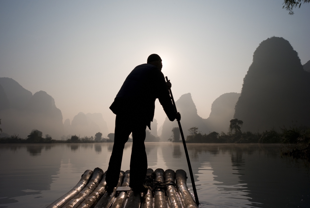 Man On Raft in Mountain Area Poster Print - 20 x 13
