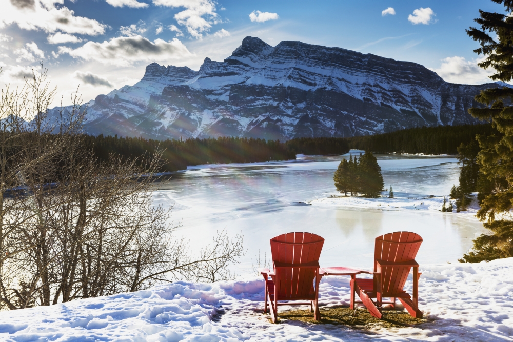Two Red Chairs on Snow Covered Ridge Overlooking Frozen Lake with Snow Covered Mountain in The Background with Blue Sky Poster Print - 19 x 12 in.