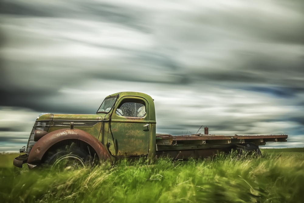 Long Exposure of Clouds Drifting by Over An Abandoned Truck - Saskatchewan Canada Poster Print - 19 x 12 in.