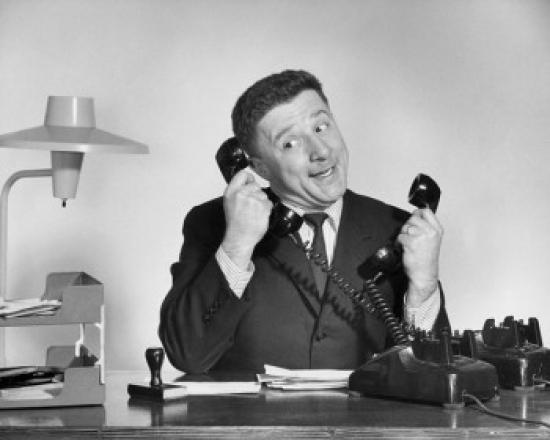 Businessman Using Two Telephones Poster Print - 18 x 24