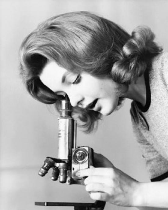 Close-Up of A Young Woman Looking Through A Microscope Poster Print - 18 x 24