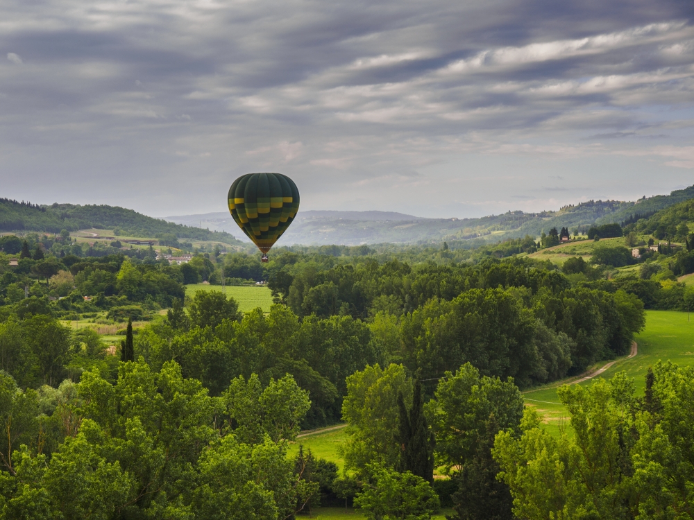DPI12273438 A Hot Air Balloon Flies Low Over A Spring Valley Landscape - Tuscany Italy Poster Print - 17 x 13 in.