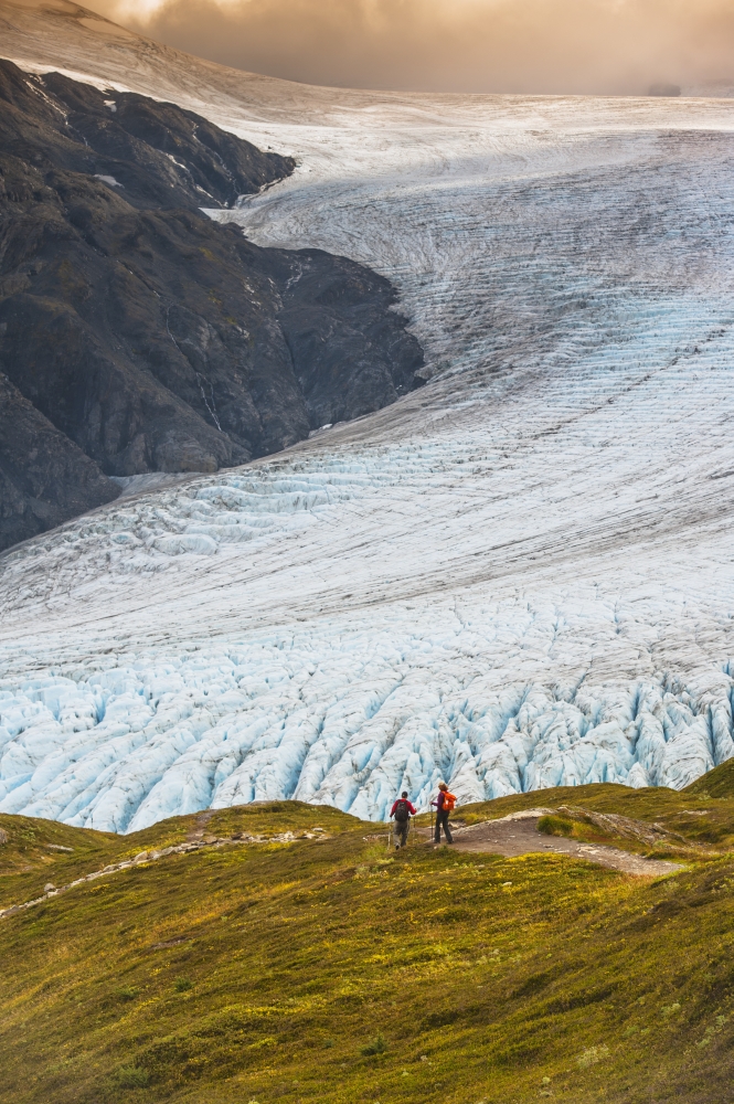 A Man & Woman Hiking Down The Harding Ice Field Trail with Exit Glacier in The Poster Print - 24 x 38 in. - Large