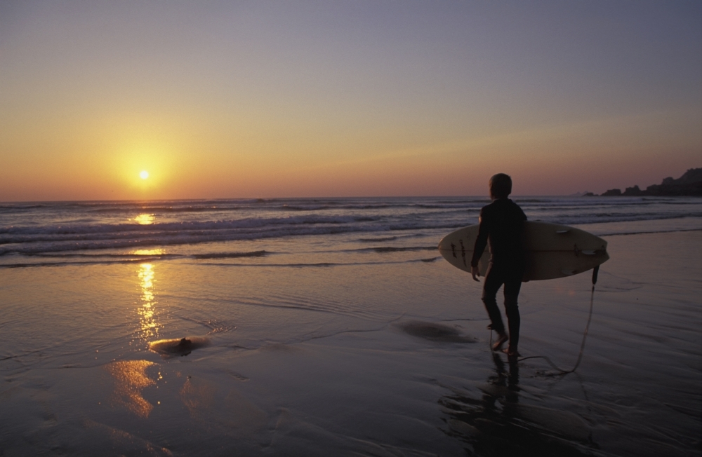 Silhouetted Surfer On Sandy Beach At Sunset Poster Print