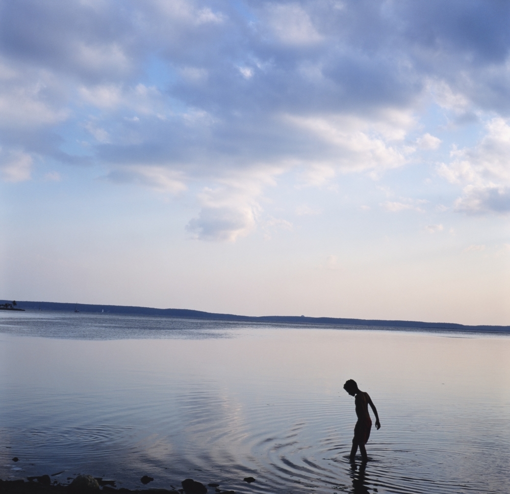 Boy In Silhouette Wading In Ocean Poster Print - 14 x 14